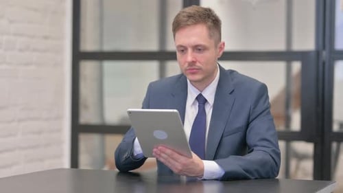 Young Businessman Using Digital Tablet in Office