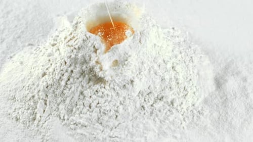 The Super Slow Motion of the Fresh Egg Falls Into the Pile of Flour Filmed on a Highspeed Camera at