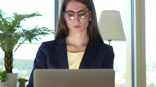 Professional Woman Works on Laptop in Bright Office
