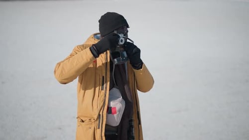 Man Taking Picture with Vintage Camera in Winter