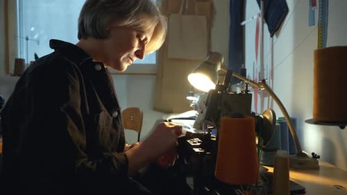 Woman Using Antique Sewing Machine in her Workshop