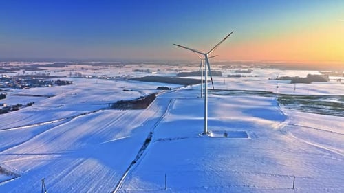 Alternative energy in winter. Wind turbine on winter snowy field.