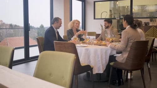 Smiling coworkers in restaurant talking during business lunch.