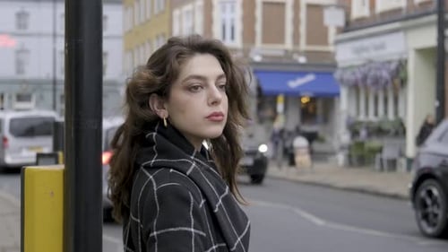 Empresária morena esperando e tentando atravessar a movimentada faixa de pedestres de uma rua no centro de Londres.