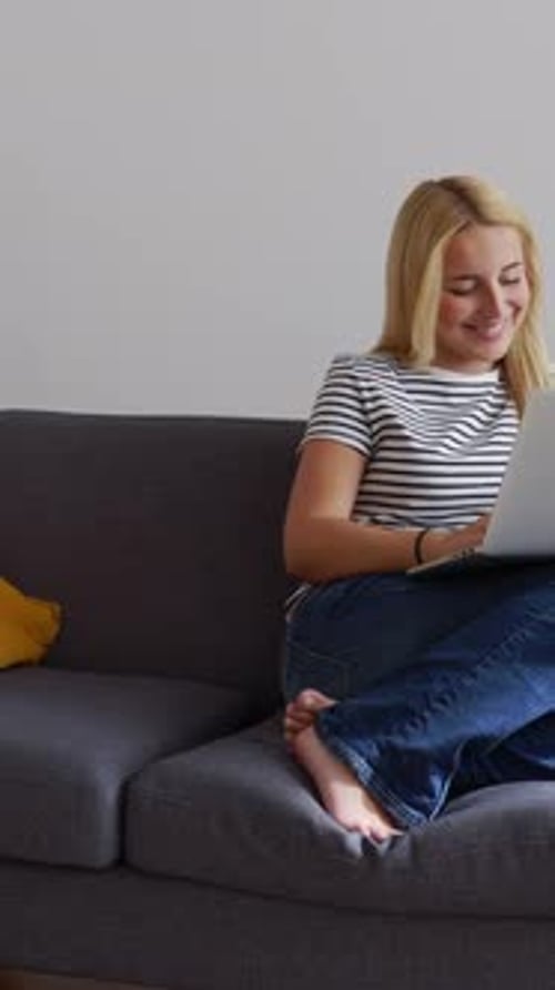 Woman Using Laptop Computer at Home on Couch