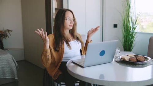 Woman in Wheelchair Video Conferencing at Home on Laptop