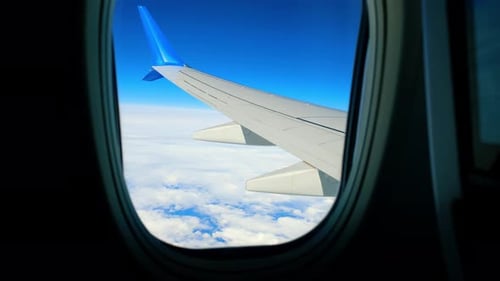 Vue panoramique depuis la fenêtre de l'avion Vue dégagée depuis la fenêtre d'un avion montrant une aile recouverte de nuages