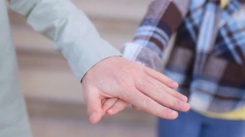 Fröhliche rothaarige Geschwister klatschen beim verspielten High-Five im Freien in die Hände