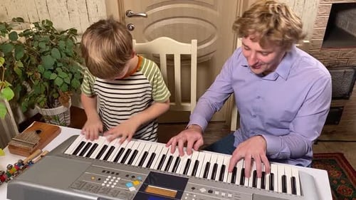 Father and Child Play Keyboard Together at Home