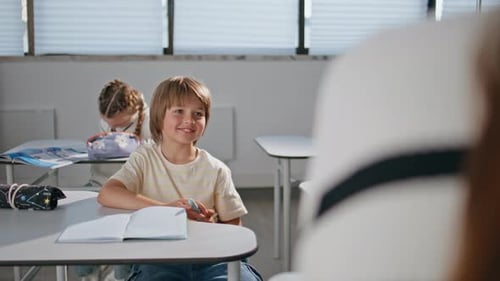Boy Smiling at Teacher in Elementary School Classroom