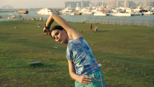Young Woman Exercising Stretching Body in Park in City 30s