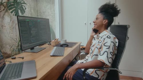 Female Programmer Having Phone Talk in Home Office