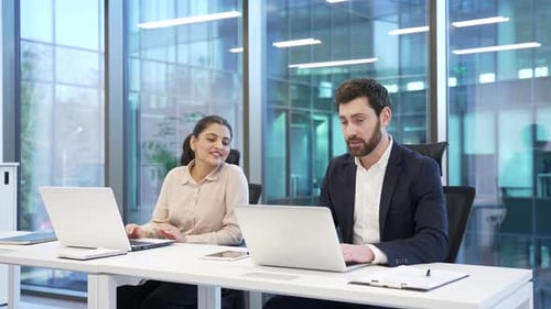 Smiling Coworkers Talking About Technology in Modern Office