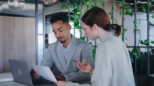 Man and Woman Collaborate on Project in Office