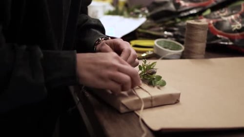 Girl wrapping the book in craft paper ES