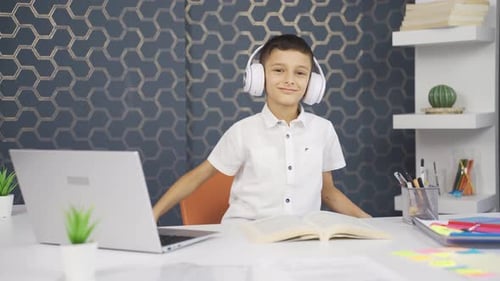 Child Wearing Headphones Listening to Music at Desk