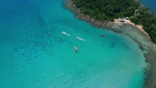 Turquoise Ocean Water and Boats Cruising Near Coastline of Tropical Island