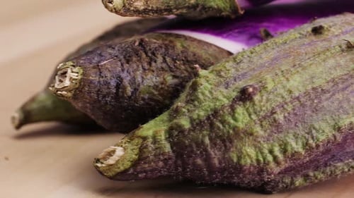 A Violet Eggplant is Placed on a Wooden Cutting Board Showcasing the Beauty of This Terrestrial