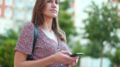 Woman Using Smartphone on City Street