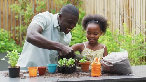 Father and Daughter Planting Plants in Garden