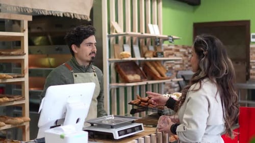 Baker Serving Customer Fresh Bread in Bakery Shop