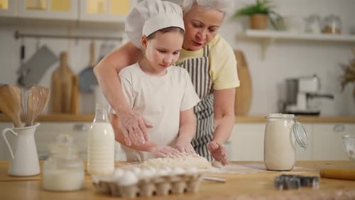 Child and Senior Baking Together in Kitchen