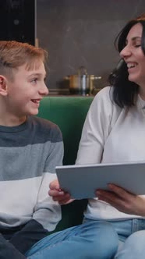Boy and Woman with Tablet Smiling in Living Room