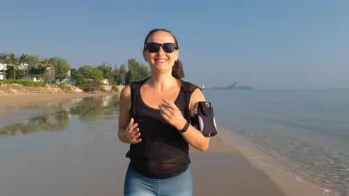 Young Woman in Sportswear Running Along the Beach