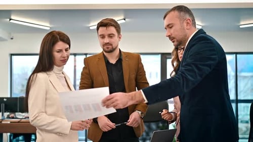 Business meeting in an office, workers discussing business affairs using papers with charts. Slow mo
