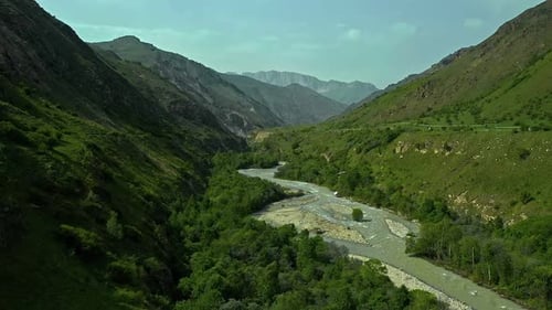 Majestic Mountains and Serene River in a Green Valley