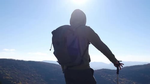 Hiker Stands on Hilltop Overlooking Valley