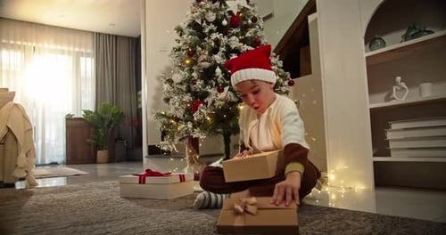 Excited Child Opening Christmas Present at Home