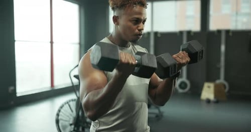 Man Curls Weights in a Gym