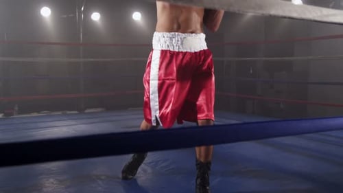 Young Man Boxing in Ring with Red Boxing Gloves