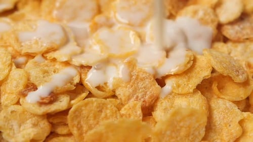 Milk Being Poured on Golden Corn Flakes