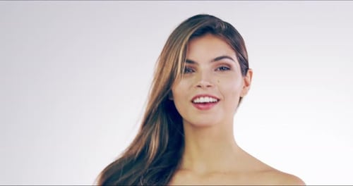 4k video footage of a beautiful young woman flicking her hair in the studio
