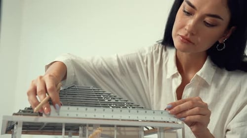 Professional architect using ruler measuring model roof length. Immaculate.