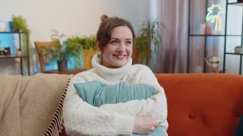 Smiling Woman Hugging Pillow on Cozy Sofa