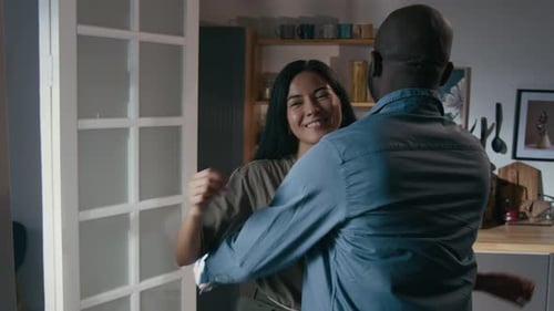Woman with Military T-Shirt Hugging Man in Home
