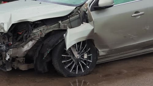Intense Damage From Severe Car Accident A CloseUp View of a Crushed Vehicle and Its Wheel Shown