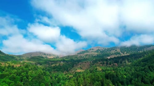 Luftaufnahme der üppigen grünen Berge mit sich bewegenden Wolken