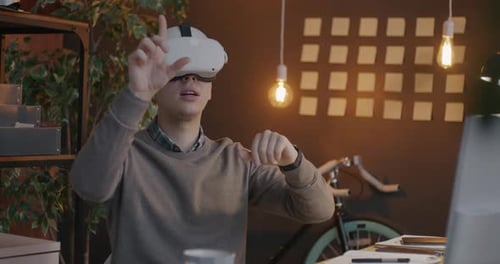 Cheerful Entrepreneur Using Augmented Reality Glasses Moving Hands Relaxing in Office During Work