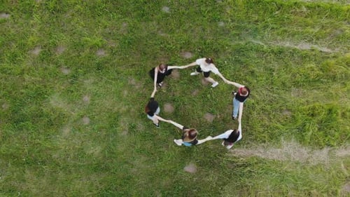 Girls are Holding Hands Spinning in a Circle in the Summer Day