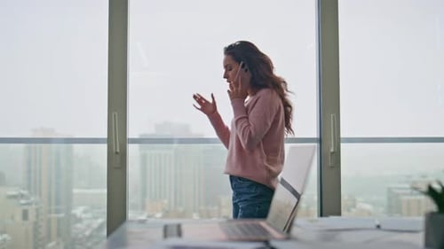 Woman Talking on Cell Phone in City Office