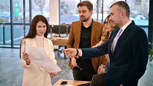 Business meeting in an office, workers discussing business affairs using papers with charts. Slow mo