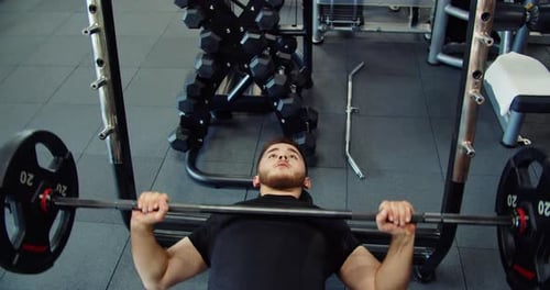 Medium Shot of Athletic Handsome Young Man Performing Bench Press in Gym Man Wears Black Long Sleeve