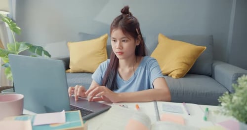Young Woman Studying with Laptop at Home