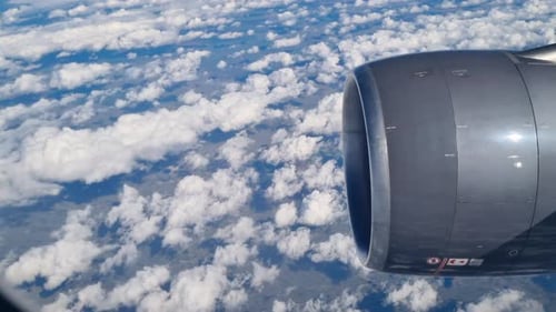 View From Inside Through Airplane Window or Porthole of Airplane Commercial Plane Flying Above White