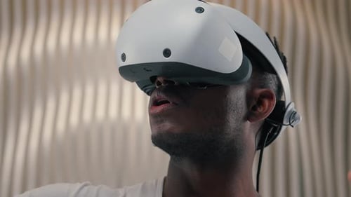 Man Wears Virtual Reality Headset and Uses Controllers