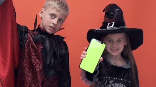 Kids in Costumes Holding Phone with Green Screen